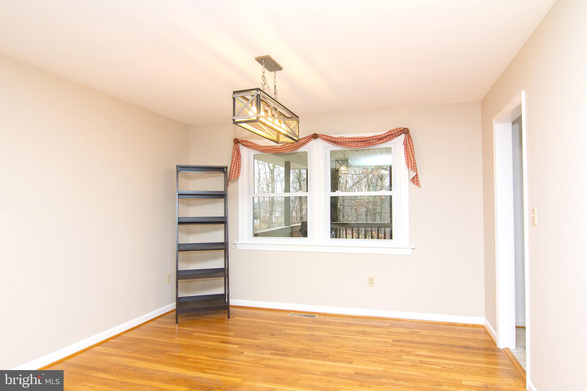 4813 Millers Station Road Hampstead, MD 21074 - Photo 7 of 32 a view of a bedroom with a window and wooden floor