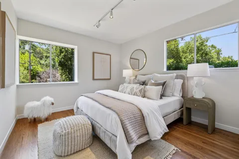 a bedroom with bed and a large window