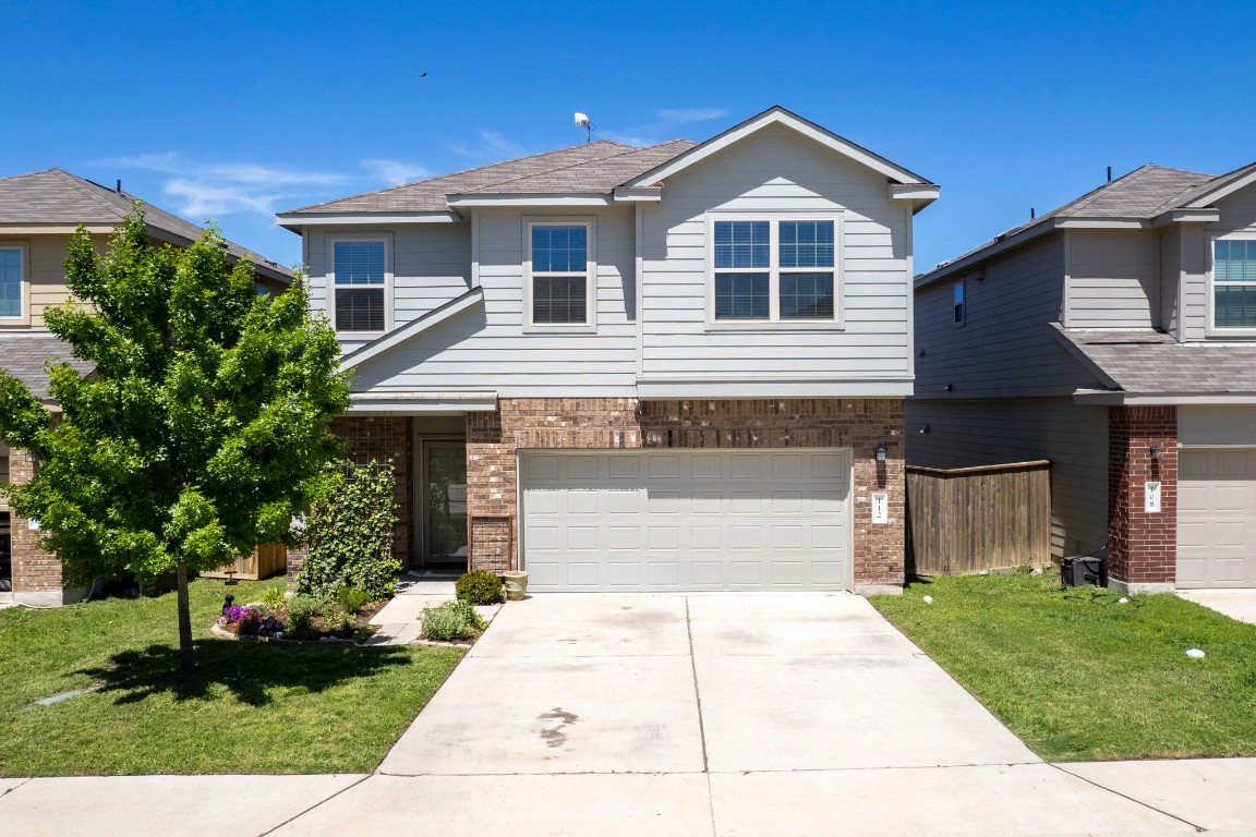a front view of a house with a yard and potted plants