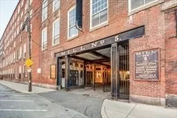 a view of a brick house with a large tree