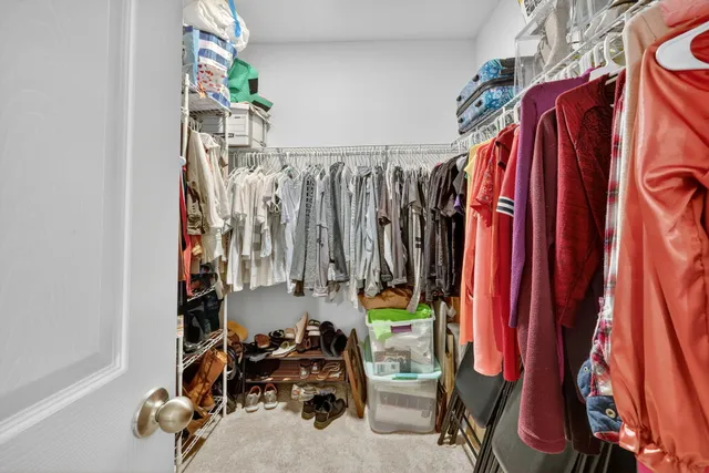 a view of walk in closet with clothes and shoes