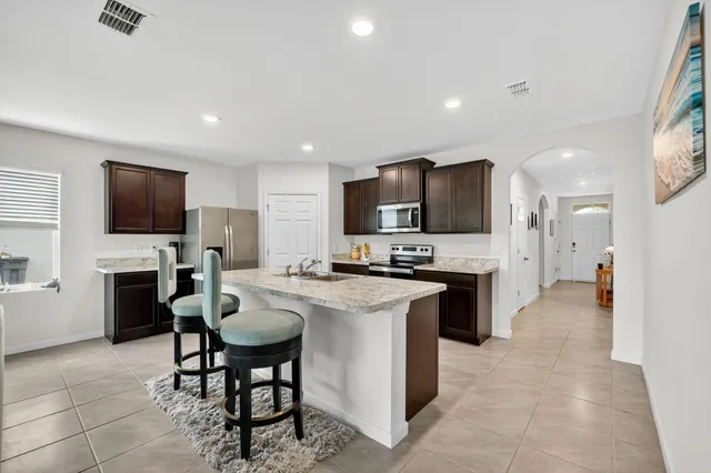 a kitchen with microwave a stove and chairs