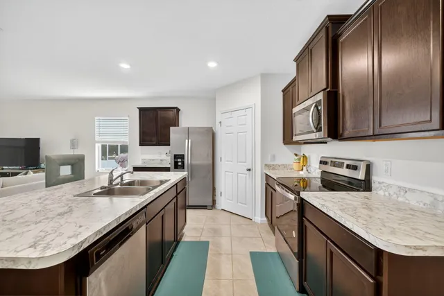 a kitchen with stainless steel appliances granite countertop a sink stove and refrigerator