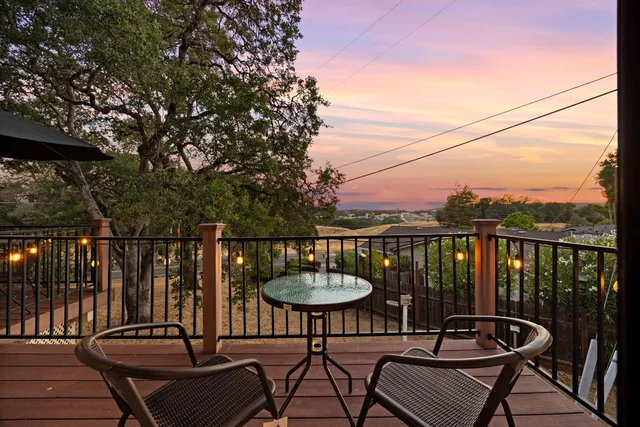 a view of a balcony with chairs and a potted plant