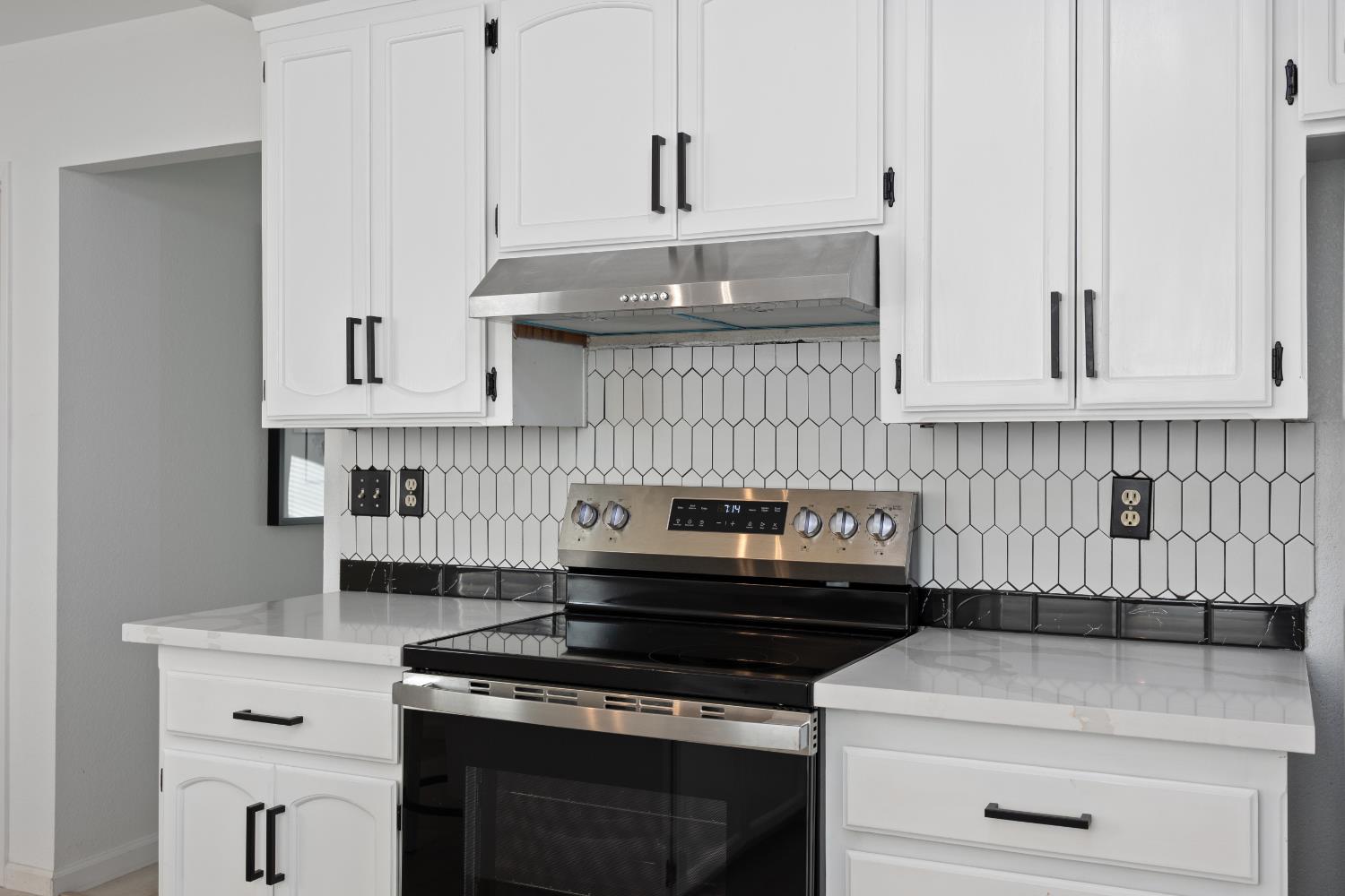 3980 Rustic Road Cameron Park, CA 95682 - Photo 12 of 42 a kitchen with a stove and white cabinets