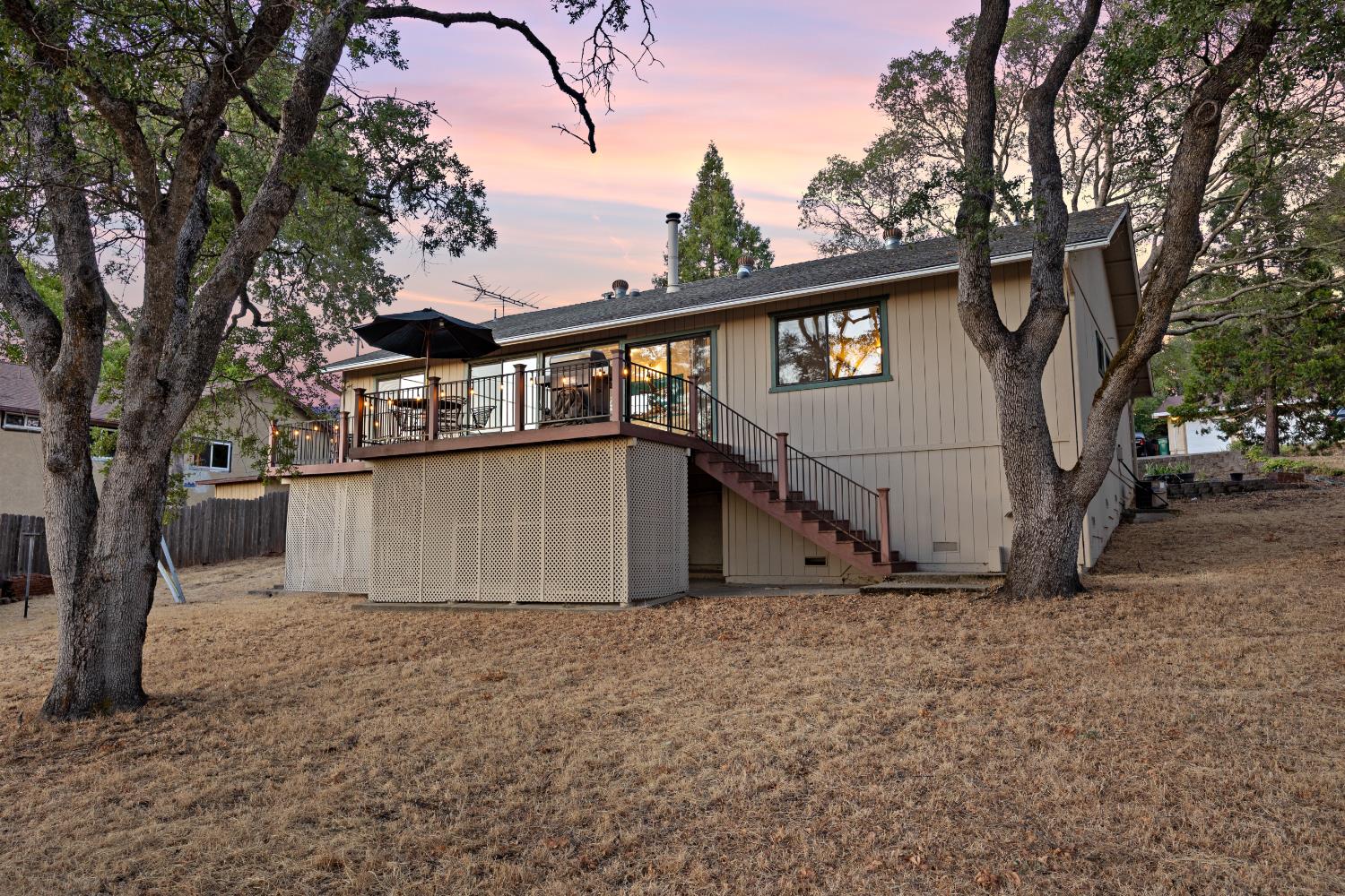 3980 Rustic Road Cameron Park, CA 95682 - Photo 29 of 42 a view of a house with a large tree and wooden fence