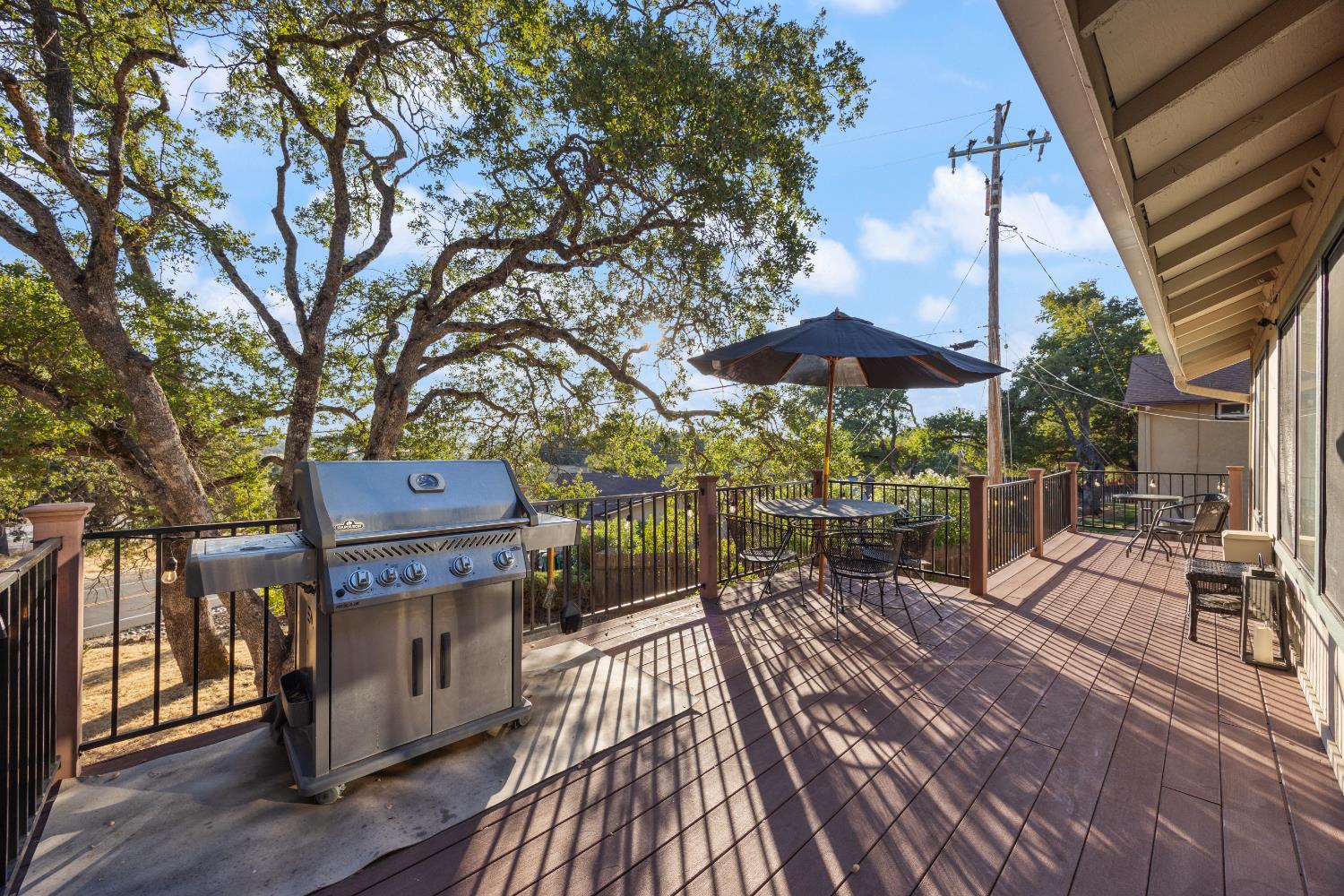 3980 Rustic Road Cameron Park, CA 95682 - Photo 37 of 42 a view of a patio with table and chairs under an umbrella with wooden floor
