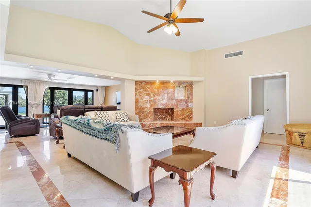 a living room with fireplace furniture and a large window