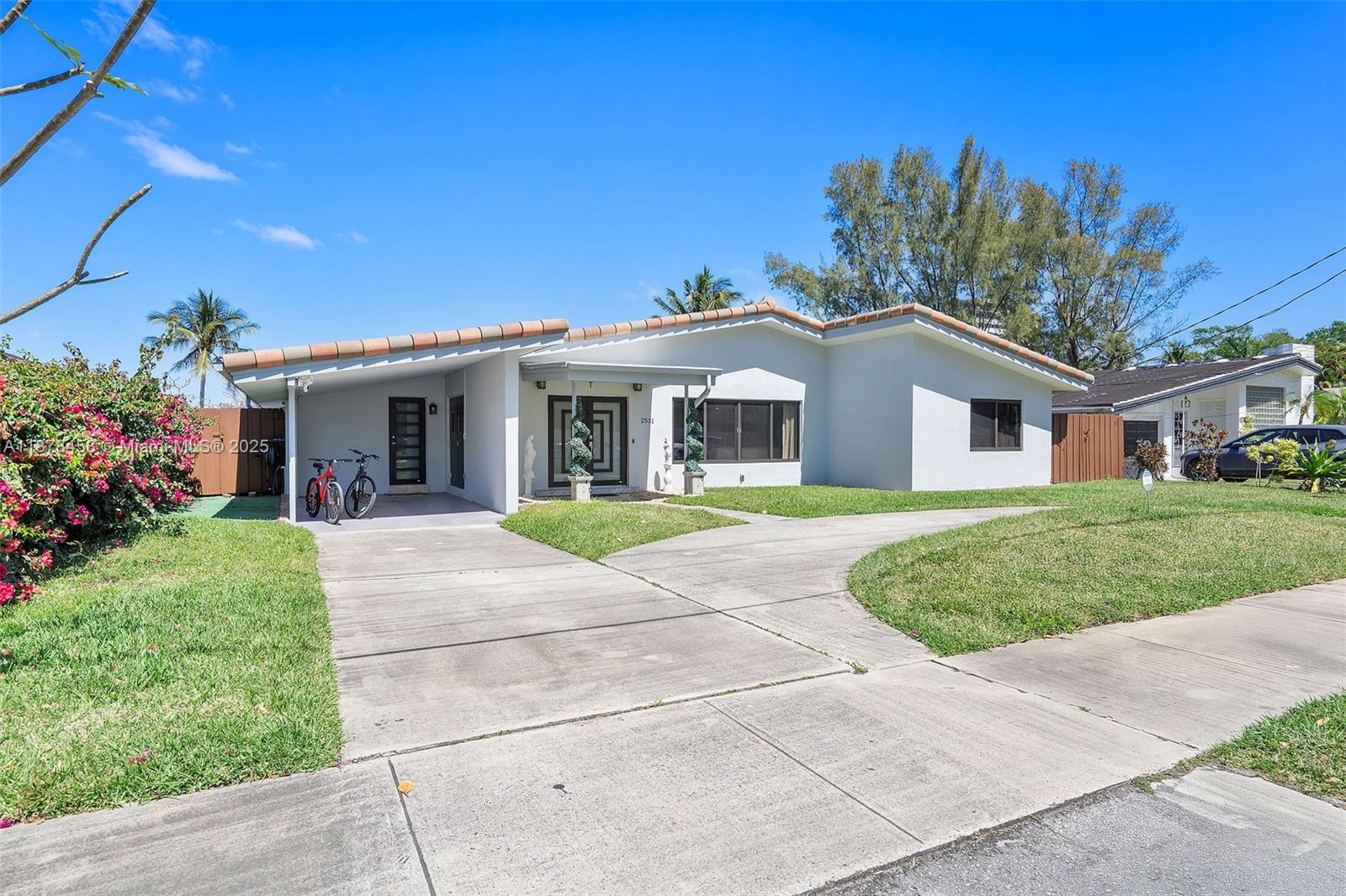 2531 Northeast 195th Street Aventura, FL 33180 - Photo 3 of 45 a front view of a house with a garden