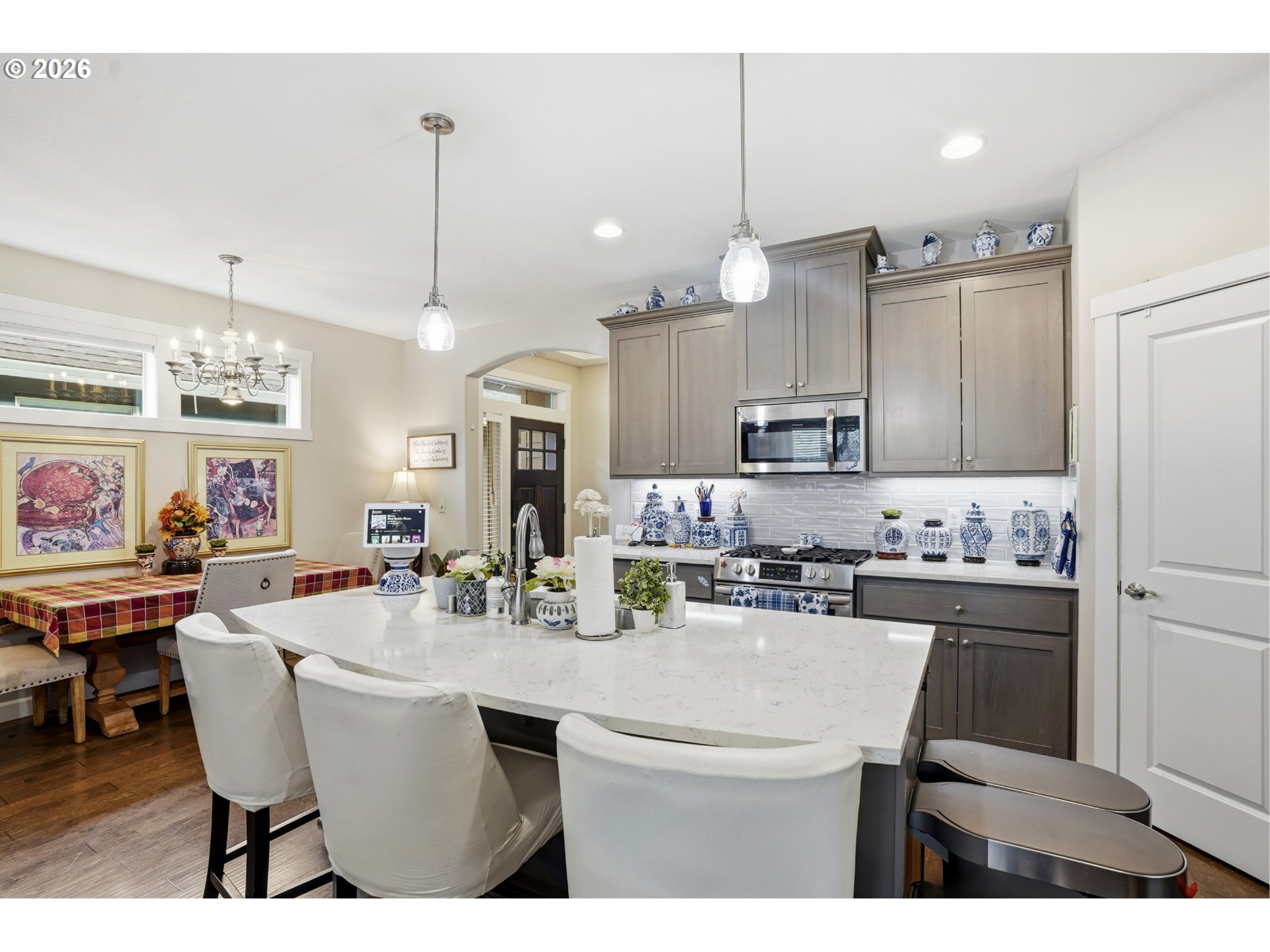 17314 Northeast 17th Avenue Ridgefield, WA 98642 - Photo 10 of 25 a kitchen with stainless steel appliances kitchen island granite countertop a dining table chairs and white cabinets