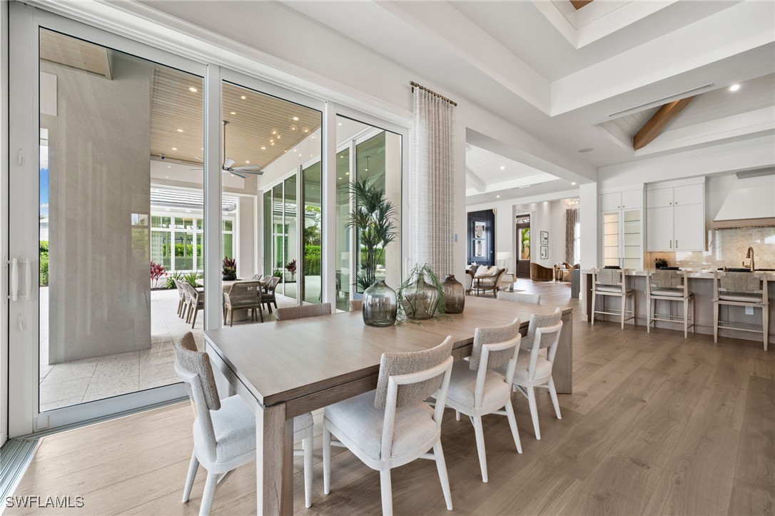39 Cajeput Drive Naples, FL 34108 - Photo 17 of 50 a view of a dining room with furniture and wooden floor
