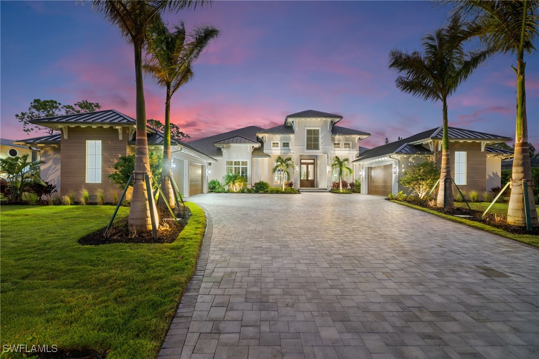 39 Cajeput Drive Naples, FL 34108 - Photo 2 of 50 a front view of a house with a yard and potted plants