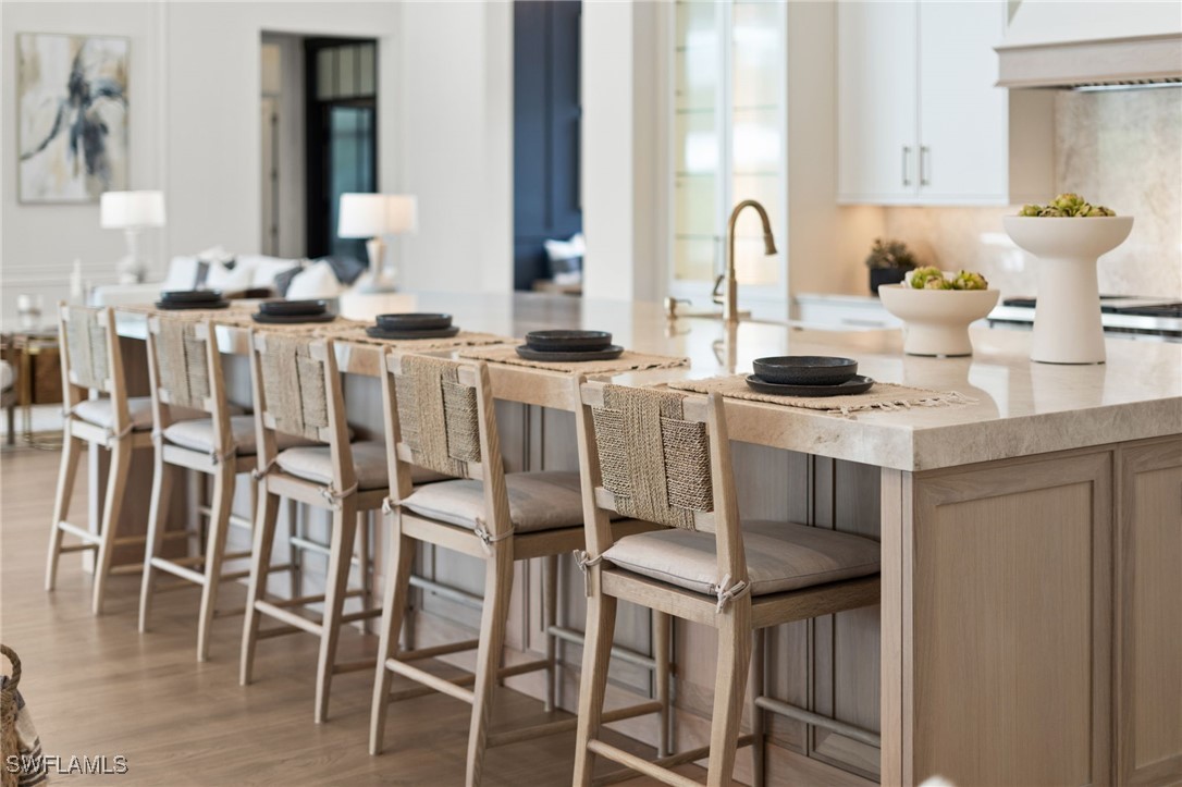 39 Cajeput Drive Naples, FL 34108 - Photo 44 of 50 a kitchen with stainless steel appliances kitchen island granite countertop a table chairs sink and white cabinets