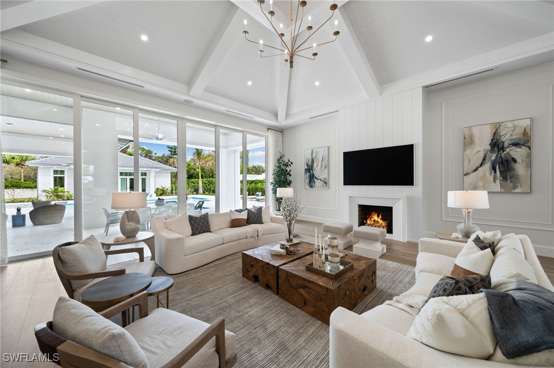 39 Cajeput Drive Naples, FL 34108 - Photo 10 of 50 a living room with furniture a flat screen tv and a large window