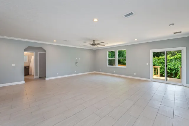 a view of a backyard with plants and large trees