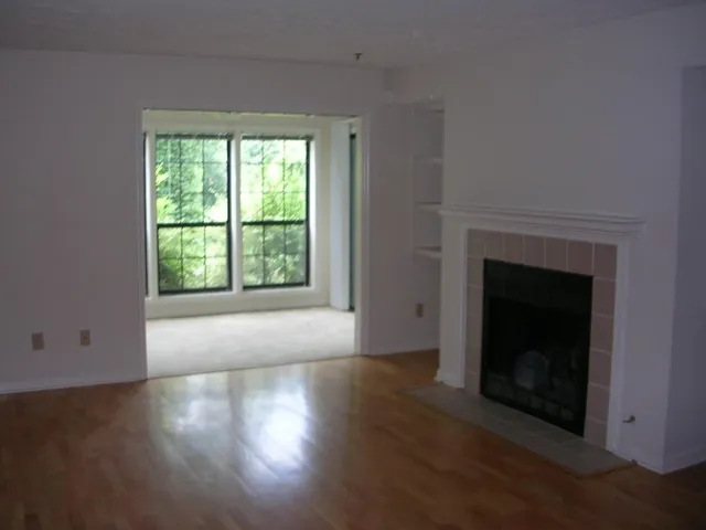 a view of an empty room with window and fireplace