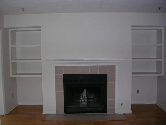 an empty room with windows and a fireplace