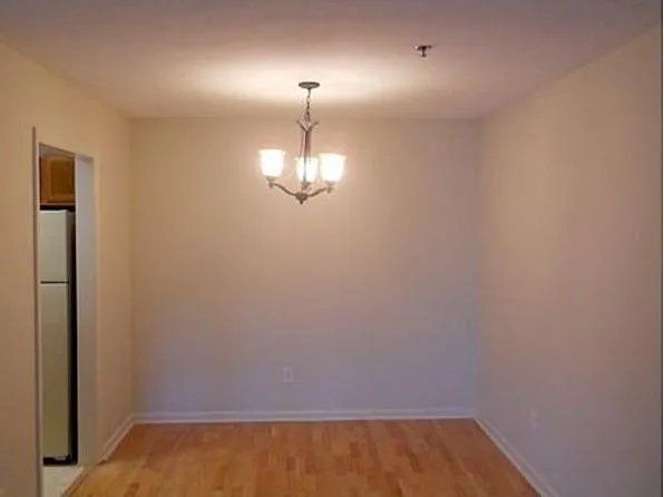 a view of an empty room with chandelier fan