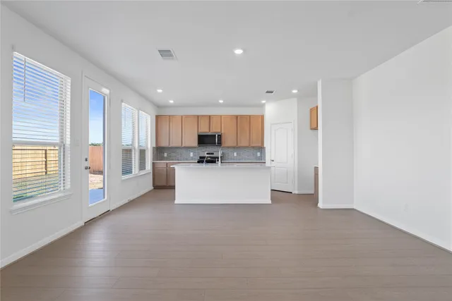 a view of kitchen with kitchen island white cabinets and refrigerator