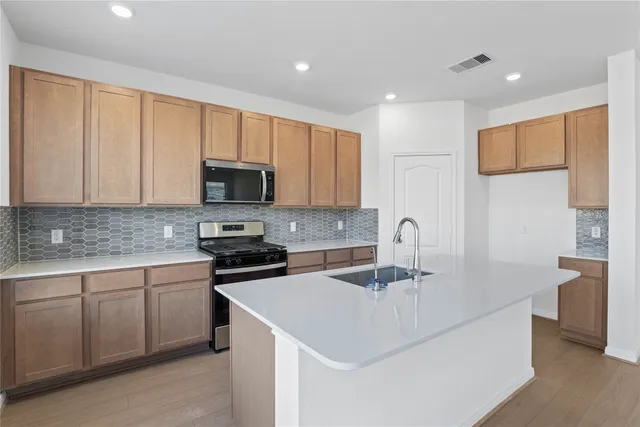 a kitchen that has a sink and a stove top oven