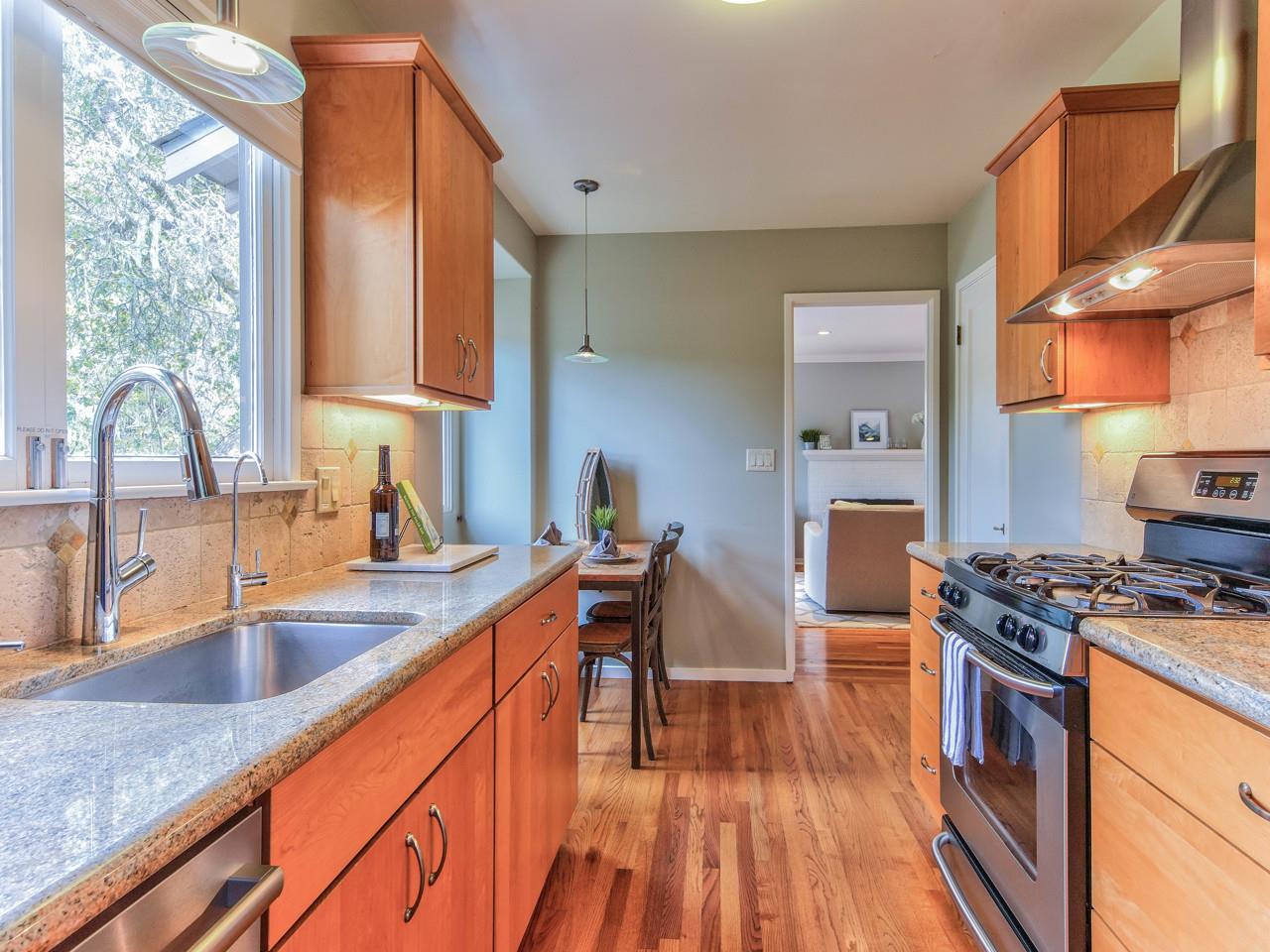 3 11th Avenue Carmel, CA 93923 - Photo 13 of 26 a kitchen with stainless steel appliances granite countertop a sink stove and wooden floor