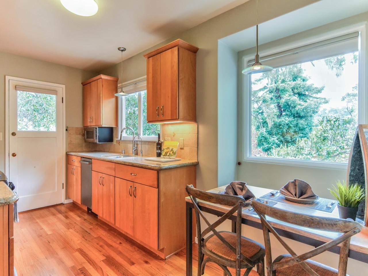 3 11th Avenue Carmel, CA 93923 - Photo 10 of 26 a kitchen with stainless steel appliances granite countertop white cabinets a table and chairs