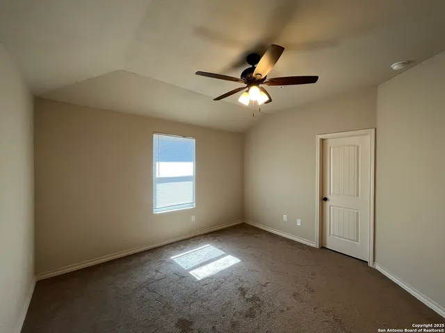an empty room with a window and a fan