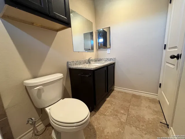 a bathroom with a toilet a sink and mirror