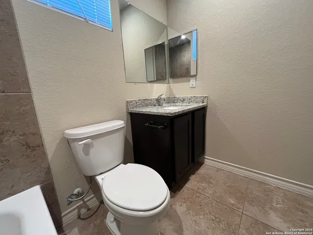 a bathroom with a toilet a sink and mirror