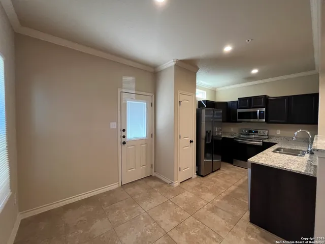 a kitchen with stainless steel appliances granite countertop a refrigerator and a sink
