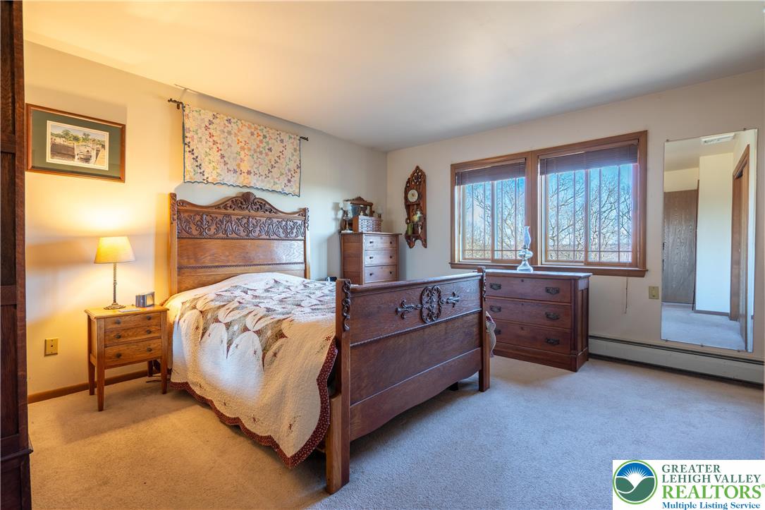 77 Uhlerstown Hill Road Erwinna, PA 18920 - Photo 23 of 47 a bed sitting in a bedroom next to a window