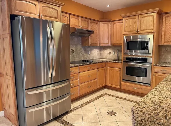 a kitchen with stainless steel appliances granite countertop a refrigerator stove and sink