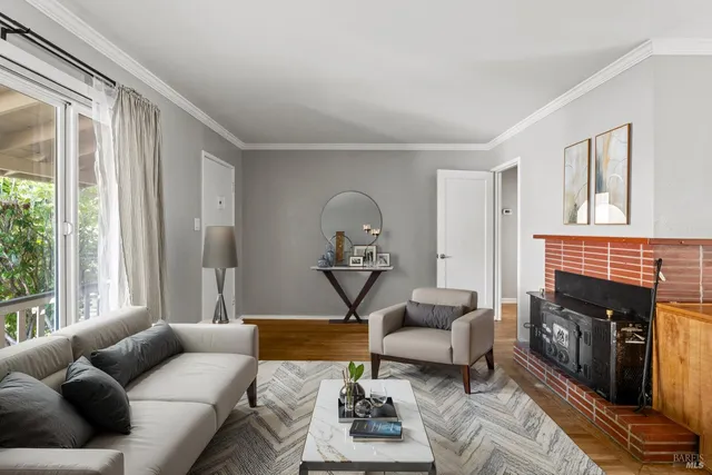 a living room with furniture a fireplace and a large window