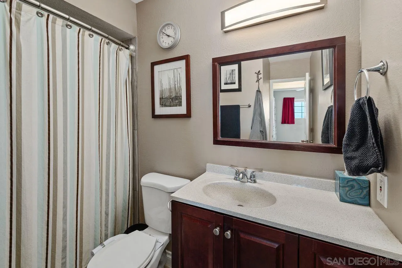 9545 Chestnut Street Spring Valley, CA 91977 - Photo 19 of 32 a bathroom with a granite countertop sink vanity mirror and toilet