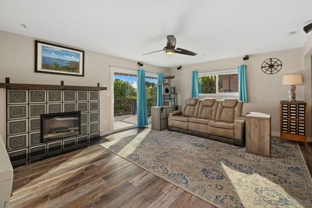 9545 Chestnut Street Spring Valley, CA 91977 - Photo 5 of 32 a living room with furniture a flat screen tv and a fireplace