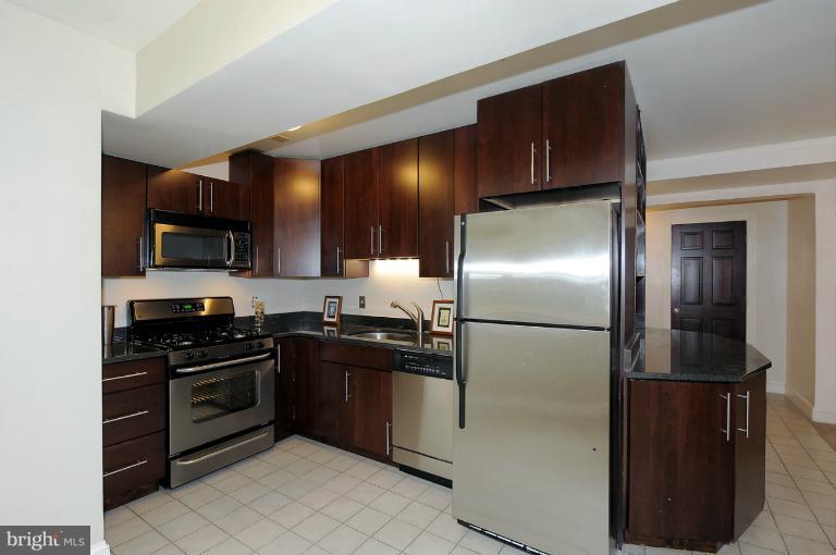 1219 Q Street Northwest Washington, DC 20009 - Photo 4 of 25 a kitchen with granite countertop a refrigerator and a stove top oven