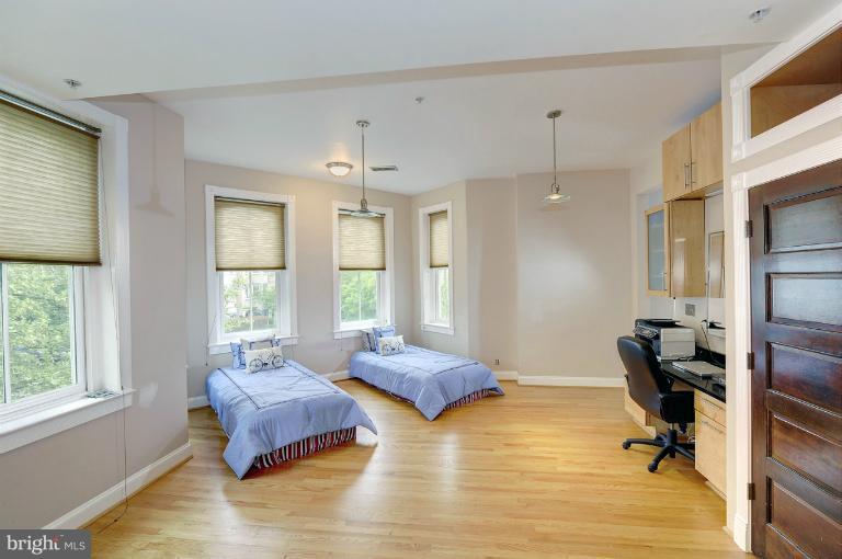 1219 Q Street Northwest Washington, DC 20009 - Photo 8 of 25 a bedroom with a bed a table and windows