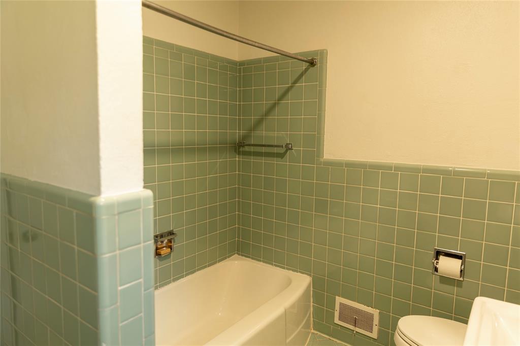 3228 Colcord Avenue Waco, TX 76707 - Photo 17 of 29 Bathroom featuring a white bathtub, green square wall tiles, and white wall paint