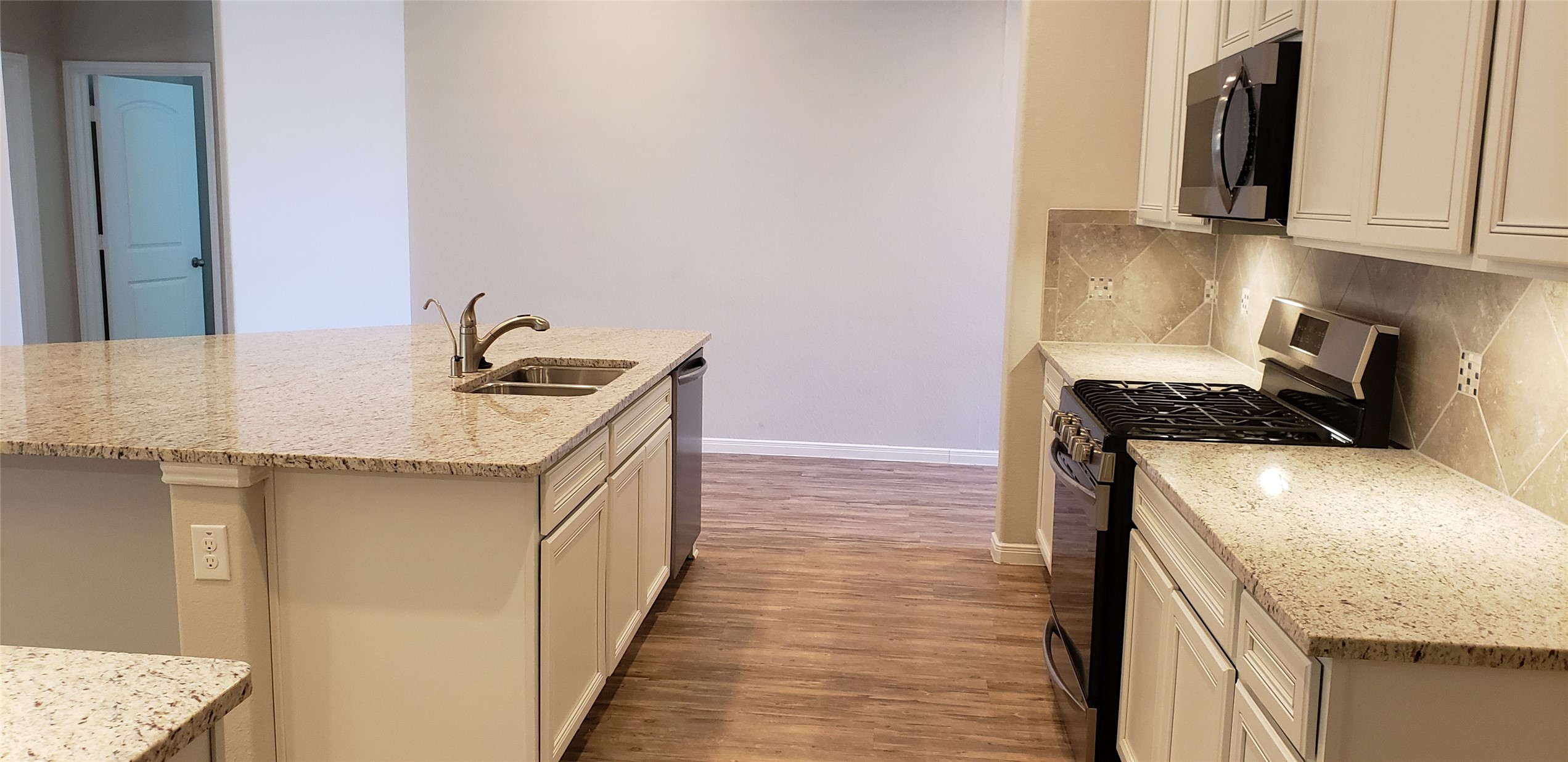 6206 Blue Coast Lane Conroe, TX 77304 - Photo 14 of 43 a kitchen with a sink and a stove top oven