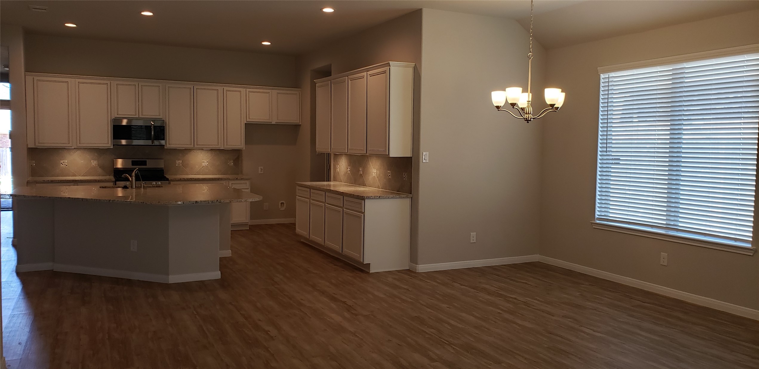 6206 Blue Coast Lane Conroe, TX 77304 - Photo 5 of 43 a kitchen with kitchen island granite countertop stainless steel appliances a sink cabinets and wooden floor