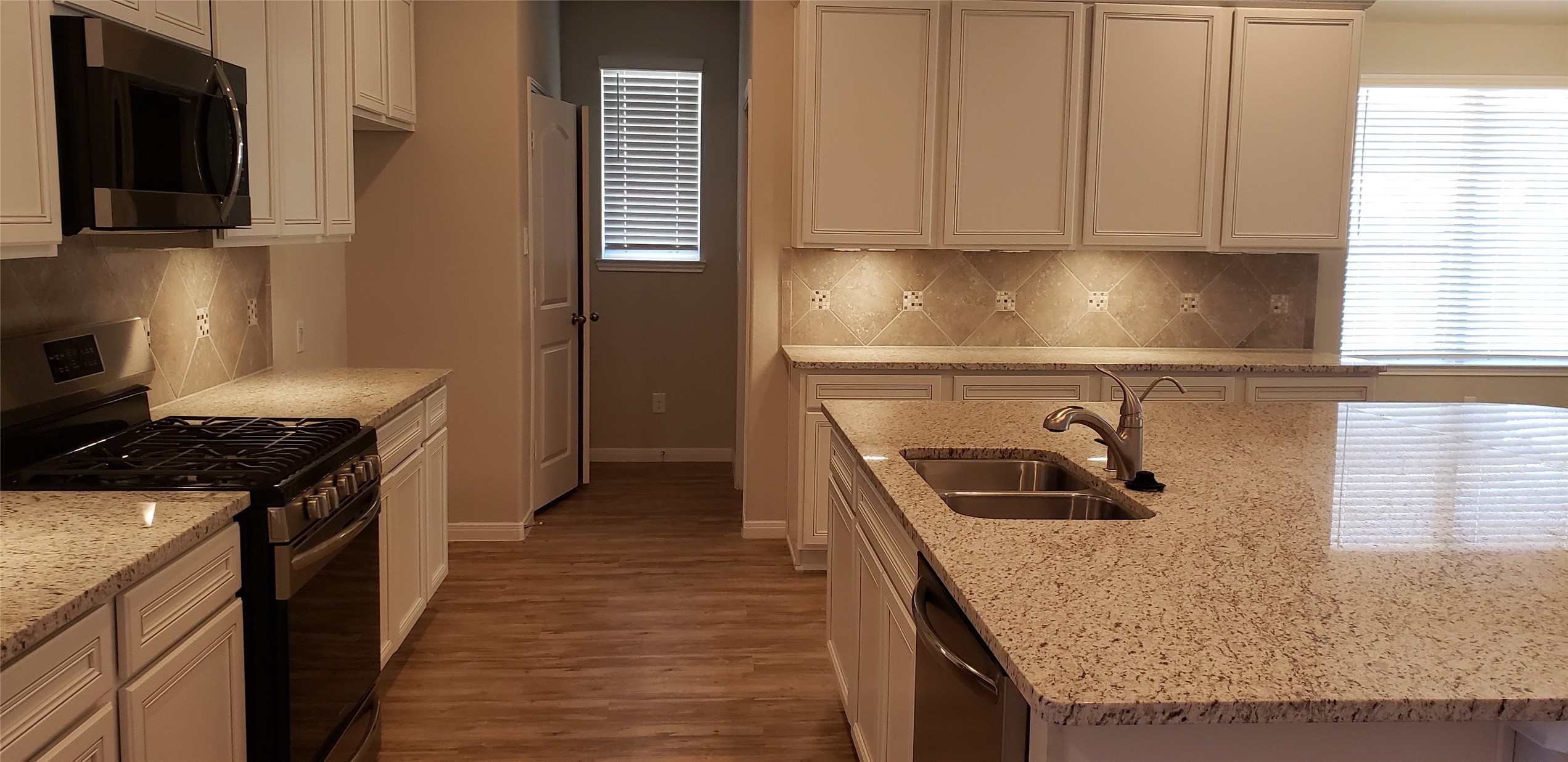6206 Blue Coast Lane Conroe, TX 77304 - Photo 10 of 43 a kitchen with granite countertop a sink a stove and refrigerator