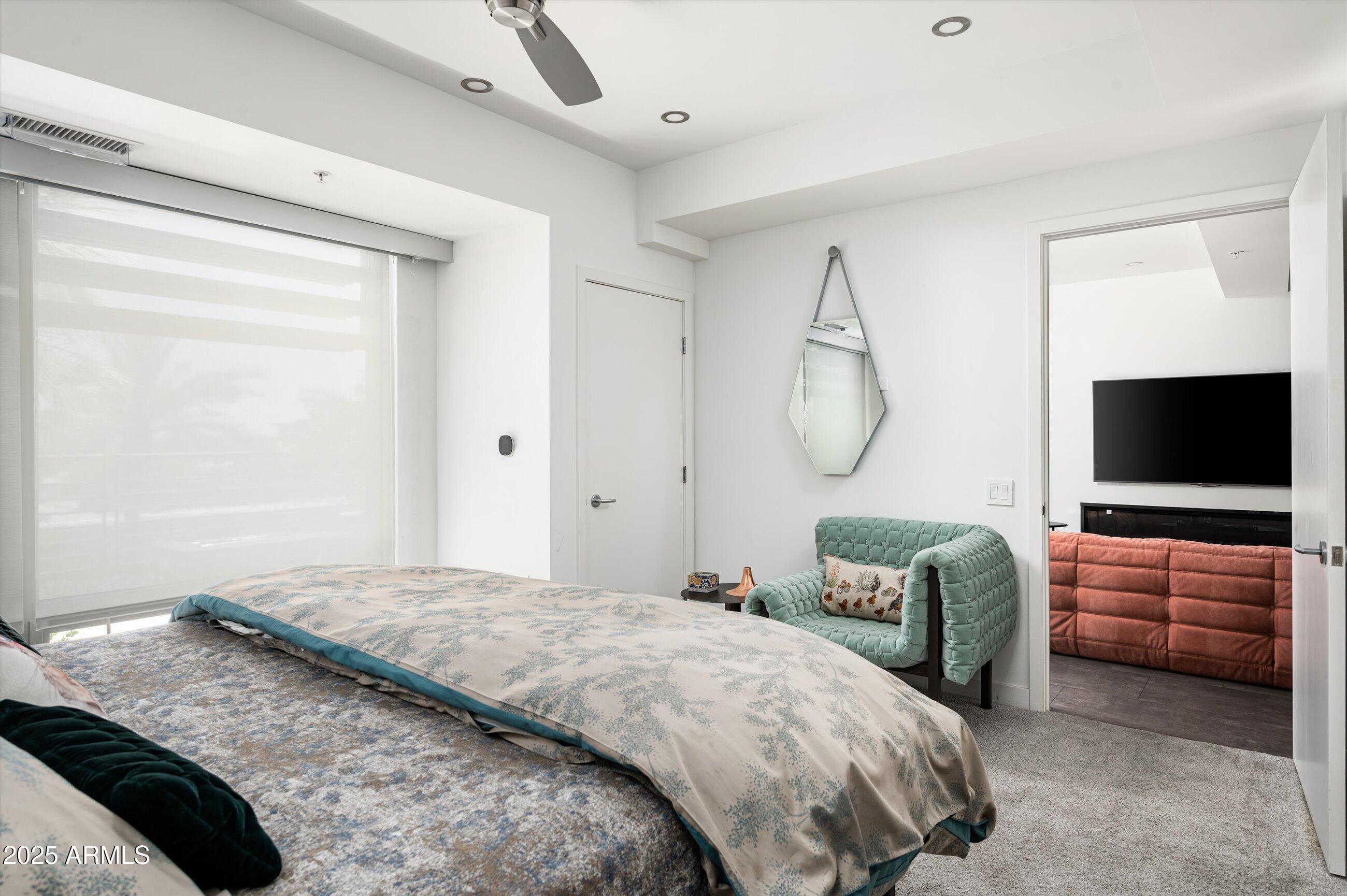 7167 East Rancho Vista Drive, Unit 4010 Scottsdale, AZ 85251 - Photo 10 of 43 a bedroom with a bed and glass door