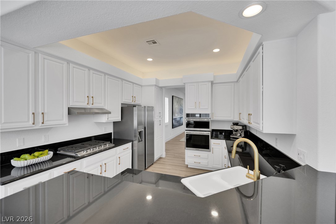 8981 Rivers Edge Drive Las Vegas, NV 89117 - Photo 18 of 69 Culinary aspirations meet sleek design in this chef's kitchen, featuring modern appliances and ample counter space.