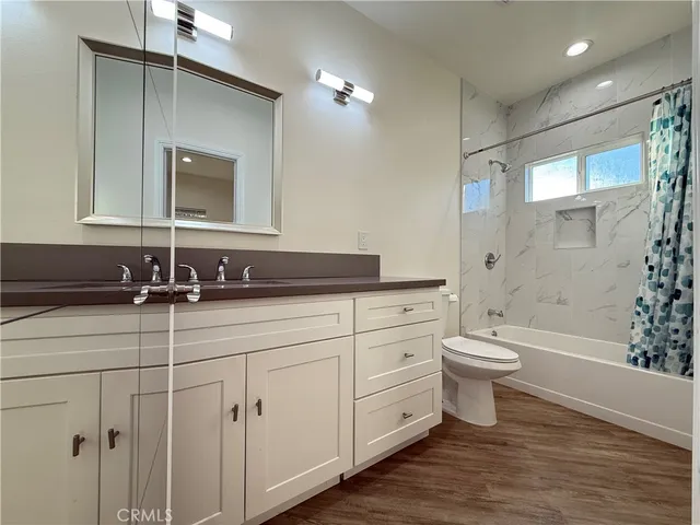 a bathroom with a granite countertop sink a toilet and shower