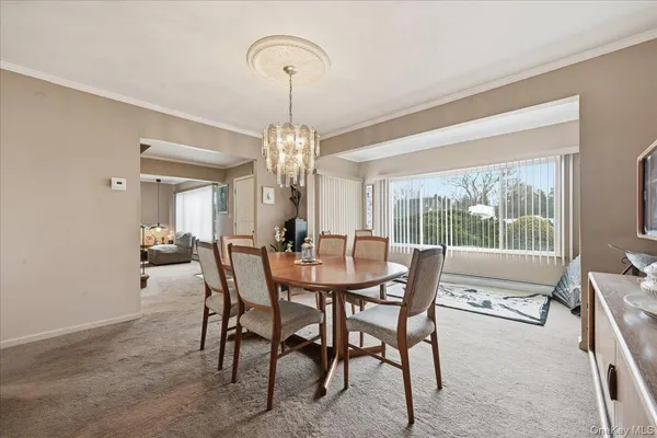 a dining room with furniture a chandelier and a rug