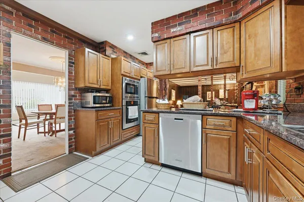 a kitchen with stainless steel appliances granite countertop a refrigerator and a stove top oven