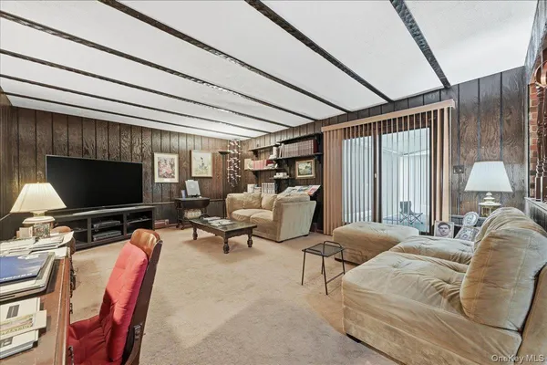 a living room with furniture a flat screen tv and a large window