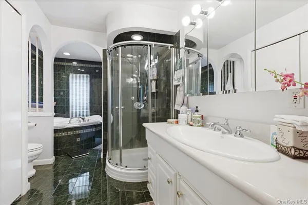 a bathroom with a sink a toilet and shower