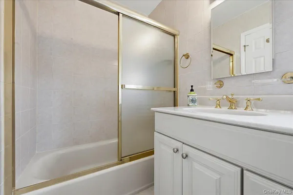 a bathroom with a bathtub sink vanity and mirror