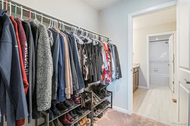 a view of walk in closet with clothes